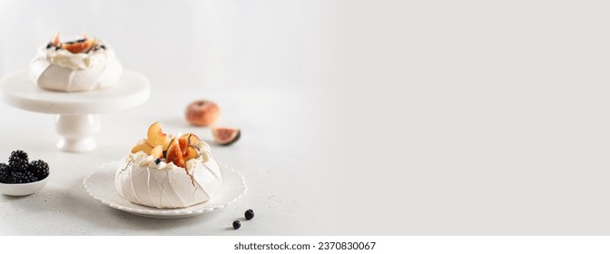 Delicious Pavlova cakes banner. Yummy meringue summer dessert with fresh blueberry, peach, figs, blackberry and mascarpone on white background. Copy space. Confectionery web line, recipe, menu. - Powered by Shutterstock