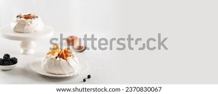 Delicious Pavlova cakes banner. Yummy meringue summer dessert with fresh blueberry, peach, figs, blackberry and mascarpone on white background. Copy space. Confectionery web line, recipe, menu.