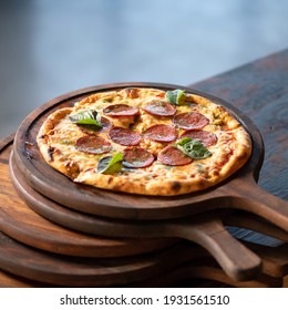 Delicious Pepperoni Pizza with salami sausage on wooden boards. Traditional italian food, top view. Nutrition dinner or lunch. Square format 1x1. Soft focus.