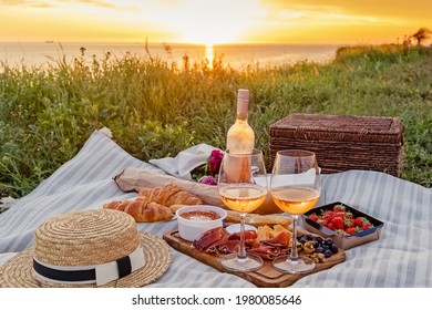 Delicious Picnic With Strawberries, Croissants And Appetizers On The Board And Rose Wine. Beautiful Sunset Light Near The Sea At Sunny Summer Day.