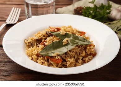 Delicious pilaf and bay leaves on wooden table, closeup - Powered by Shutterstock