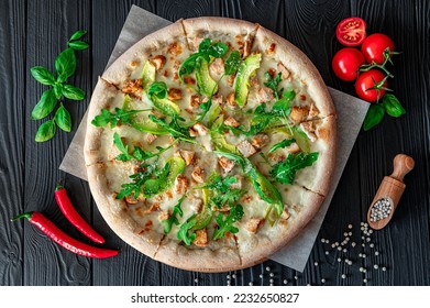 Delicious pizza with grilled chicken, avocado, and arugula. Top view of big pizza - Powered by Shutterstock