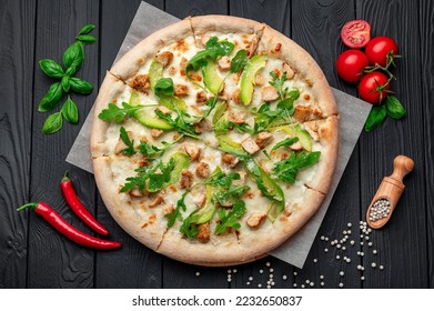 Delicious pizza with grilled chicken, avocado, and arugula. Top view of big pizza - Powered by Shutterstock