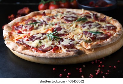 Delicious pizza with salami, tomatoes and hot peppers on wooden background - Powered by Shutterstock