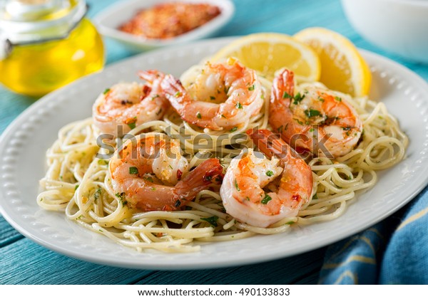 A delicious plate of shrimp scampi with spaghetti\
and lemon.