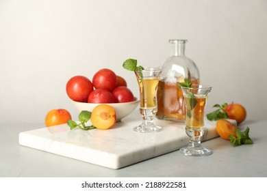 Delicious Plum Liquor With Mint And Ripe Fruits On Light Table. Homemade Strong Alcoholic Beverage