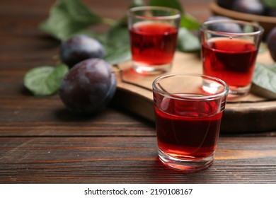 Delicious Plum Liquor On Wooden Table. Homemade Strong Alcoholic Beverage