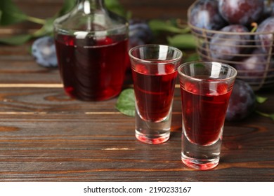 Delicious Plum Liquor On Wooden Table. Homemade Strong Alcoholic Beverage