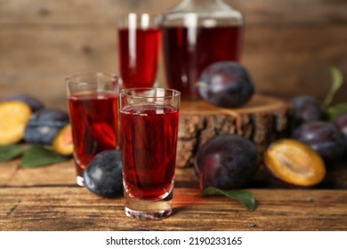 Delicious Plum Liquor And Ripe Fruits On Wooden Table. Homemade Strong Alcoholic Beverage