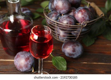 Delicious Plum Liquor And Ripe Fruits On Wooden Table. Homemade Strong Alcoholic Beverage