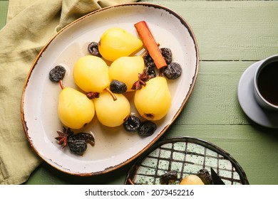 Delicious poached pears, prunes, anise and cinnamon in dish on color wooden table