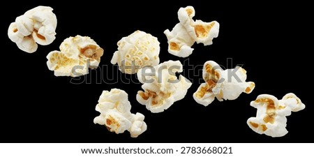 Delicious popcorn kernels floating, isolated on black background