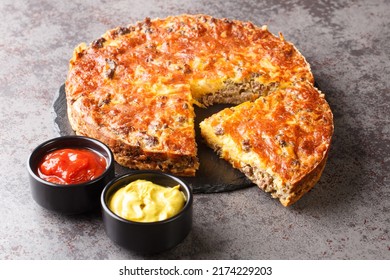 Delicious Popular Meat Cheeseburger Pie Served With Sauces Close-up On A Slate Board On The Table. Horizontal
