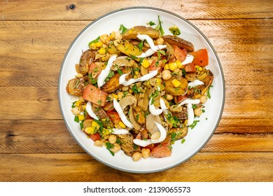 A Delicious Potato, Chickpea, Tomato And Mushroom Salad With Parsley And Aioli In An Isolated Bowl On A Wooden Table. Healthy, Homemade, Vegan Food. Top View.