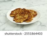 Delicious potato pancakes on white marble table, closeup