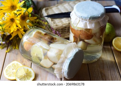Delicious preservation for winter: sweet pear compote in glass jars on a wooden table. Close-up