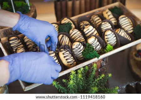 Delicious profiteroles with chocolate glaze on wooden tray