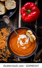 Delicious Pumpkin Soup With Heavy Cream On Dark Rustic Wooden Table With Red Bell Pepper, Bread Toasts, Lentil. Top View