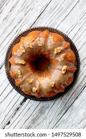 Delicious, Pumpkin Spice Bundt Cake Frosted With Brown Sugar Frosting And Walnuts Over A Rustic Wood Table Background.  Top Down View. Fall Autumn Foods.