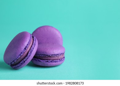 Delicious purple macarons on turquoise background. Space for text