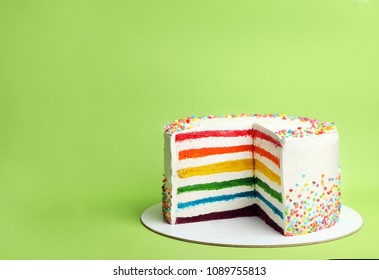 Delicious rainbow cake on color background
