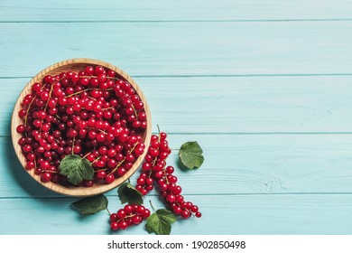 Delicious red currants and leaves on light blue wooden table, flat lay. Space for text - Shutterstock ID 1902850498