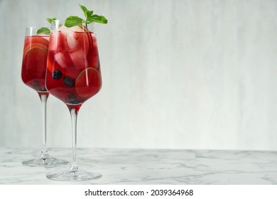 Delicious Red Sangria with fruits on white marble table, space for text