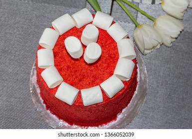 Delicious Red Velvet Cake With Marshmallow Decoration, On A Gray Background With White Tulips, View From Above