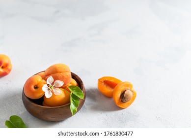 Delicious Ripe Apricots With Green Leaves In A Wooden Bowl On The Table. Side View, Copy Space For Text. Poster, Recipe, Cooking Book. Summer Fruits