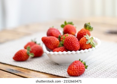 Delicious ripe fresh strawberries in a white bowl on a wooden table background - Powered by Shutterstock