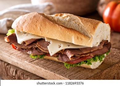 A Delicious Roast Beef Sandwich With Swiss Cheese, Lettuce And Tomato On A French Bread Baguette.