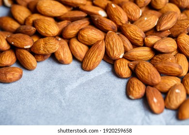 Delicious roasted sweet almonds lie in a large heap, nuts close-up.