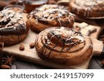 Delicious rolls with toppings and nuts on wooden table, closeup. Sweet buns