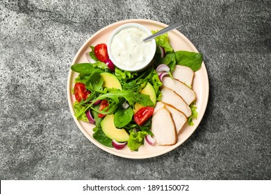 Delicious Salad With Chicken, Arugula And Avocado On Grey Table, Top View