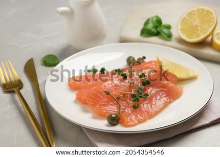 Delicious salmon carpaccio served on light grey table, closeup