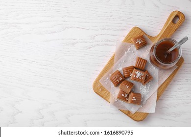 Delicious Salted Caramel On White Wooden Table, Top View. Space For Text