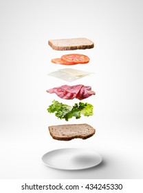 Delicious Sandwich With Floating Ingredients On White Background