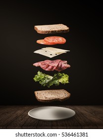 Delicious Sandwich With Floating Ingredients On The Wood Table Black Background