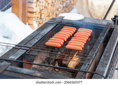 delicious sausages are grilled on a barbecue outside in winter