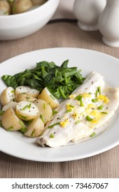 Delicious Seabass With New Potatoes And Spinach On A Plate