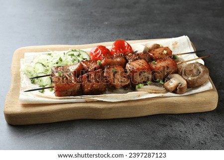 Delicious shish kebabs with vegetables and lavash on grey table