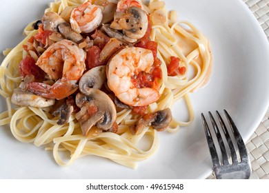 A Delicious Shrimp Scampi Dinner With Mushrooms And Diced Tomatoes On Linguine Pasta.