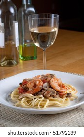 A Delicious Shrimp Scampi Over Linguine Dish Along With A Glass Of Pinot Grigio White Wine.