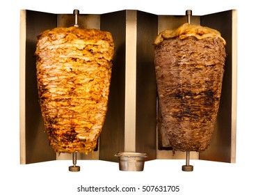 Delicious skewered fast food chicken and lamb mutton kebab, shawarma meat cooking and turning side by side on rotating spit Arab Middle Eastern or Mediterranean style.  Isolated on white background