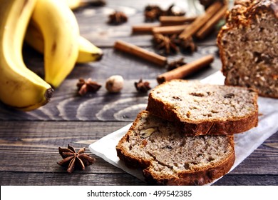 Delicious slices of homemade banana bread with nuts. Fragrant dessert for cup of tea on wooden table. Fresh bananas, cinnamon sticks, stars of anise and walnuts in the shell next to it. Banana loaf - Powered by Shutterstock