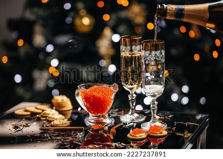 Delicious snacks with cream cheese and red caviar with glass of champagne, Festive drink. Valentins or Christmas concept.