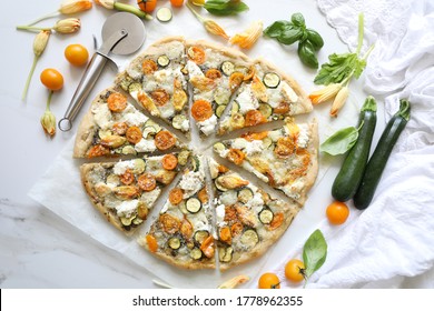 Delicious sourdough white pizza (Italian: Pizza Bianca) with basil pesto, stuffed zucchini flowers, yellow cherry tomato, Goat, Mozzarella and Ricotta Cheese. Italian healthy summer  cuisine concept  - Powered by Shutterstock