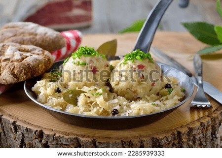 Delicious South Tyrolean bacon dumplings served on sauerkraut in an iron frying pan