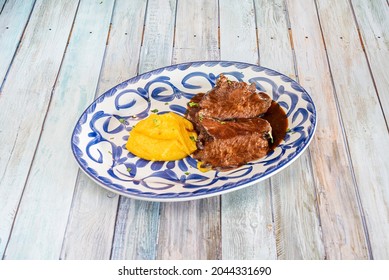 Delicious Spanish Recipe For Beef Cheek Stewed In Sauce And Sweet Potato Puree With Parsley On A Blue Porcelain Plate From Talavera