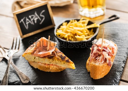 Delicious spanish tapas and beer served on a wooden table. Foto stock © 